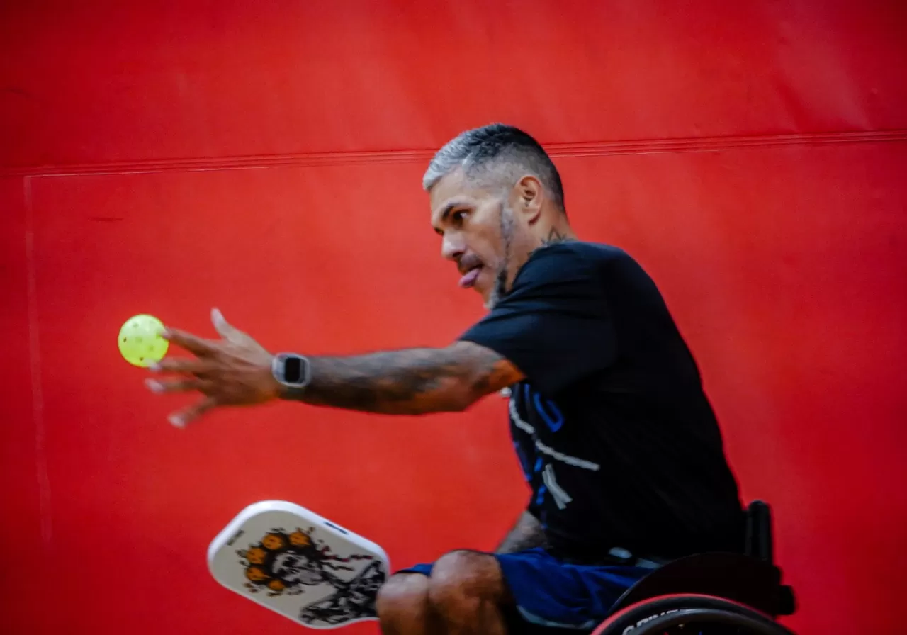 a man in a wheelchair playing pickleball