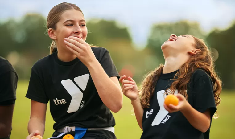 2 girls laughing while playing sports