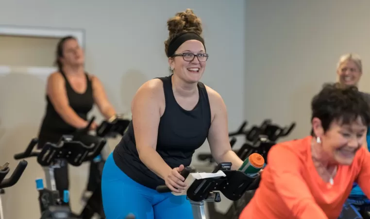 smiling woman in a cycling class