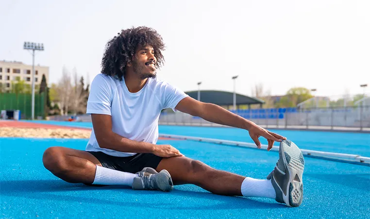man performing a hamstring stretch outdoors