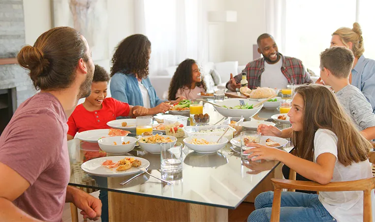 two families enjoying dinner around a dining room table