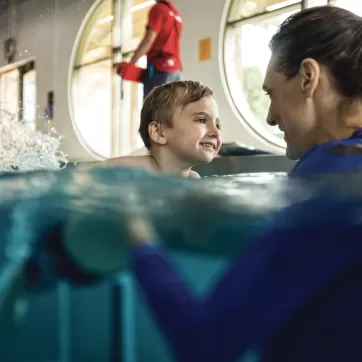 a happy child taking a swim lesson