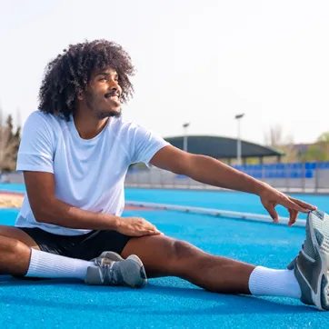 man performing a hamstring stretch outdoors