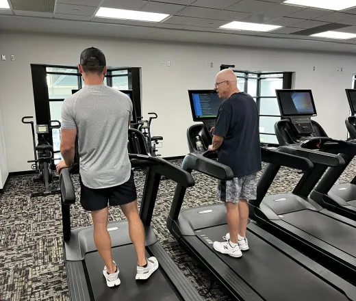YMCA trainer showing a member how to use the treadmill